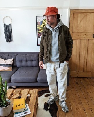 Orange Bucket Hat Outfits For Men: Consider pairing an olive bomber jacket with an orange bucket hat for an unexpectedly cool getup. Look at how nice this outfit goes with a pair of grey athletic shoes.