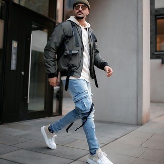 Dark Green Bomber Jacket Outfits For Men: If the setting permits off-duty style, reach for a dark green bomber jacket and light blue ripped jeans. Why not take a more refined approach with footwear and complement this getup with white canvas low top sneakers?