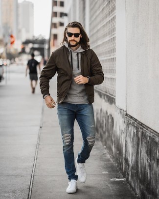 Dark Brown Bomber Jacket Outfits For Men: No matter where the day takes you, you'll be stylishly ready in this laid-back combination of a dark brown bomber jacket and blue ripped jeans. Take a more refined approach with footwear and add a pair of white canvas low top sneakers to the equation.
