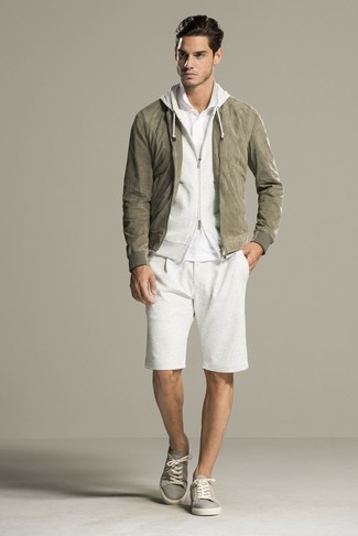 Olive Suede Bomber Jacket Outfits For Men: Rock an olive suede bomber jacket with white shorts for comfort dressing with a contemporary spin. Let your styling chops really shine by rounding off your ensemble with grey plimsolls.