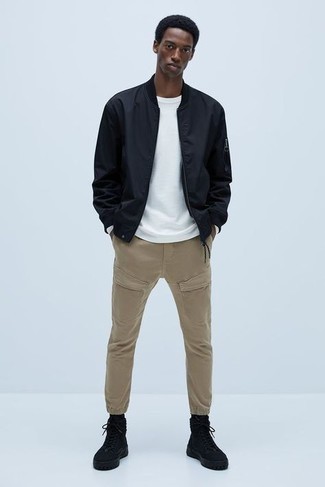 Black Bomber Jacket Outfits For Men: Parade your skills in menswear styling by teaming a black bomber jacket and khaki cargo pants for a casual combination. You can take a more casual route with footwear by sporting a pair of black canvas high top sneakers.