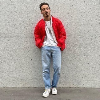 Red Quilted Bomber Jacket Outfits For Men: Wear a red quilted bomber jacket with light blue jeans for a casually stylish and trendy ensemble. Let your sartorial skills truly shine by finishing off with a pair of white canvas low top sneakers.