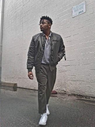 Grey Satin Bomber Jacket Outfits For Men: A grey satin bomber jacket and dark green chinos are the kind of a foolproof off-duty getup that you so desperately need when you have zero time to pick out a look. When this ensemble is just too much, play it down by finishing with a pair of white canvas high top sneakers.