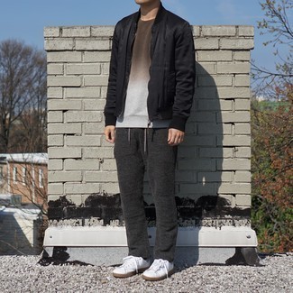 Dark Brown Sweatshirt Outfits For Men: This pairing of a dark brown sweatshirt and charcoal knit chinos is super easy to put together and so comfortable to rock a version of all day long as well! Look at how well this getup is finished off with white leather low top sneakers.