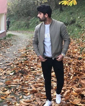 Grey Bomber Jacket Outfits For Men: This laid-back combination of a grey bomber jacket and black jeans is very easy to pull together in no time, helping you look stylish and ready for anything without spending too much time digging through your wardrobe. White and navy leather low top sneakers are a smart option to finish this getup.