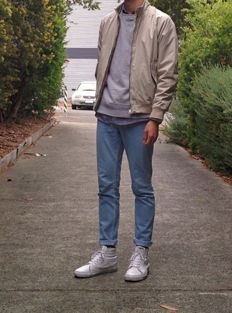 White Leather High Top Sneakers Outfits For Men: This pairing of a beige bomber jacket and light blue jeans looks amazing and makes you look infinitely cooler. And if you need to immediately dial down this ensemble with one piece, complete this getup with a pair of white leather high top sneakers.