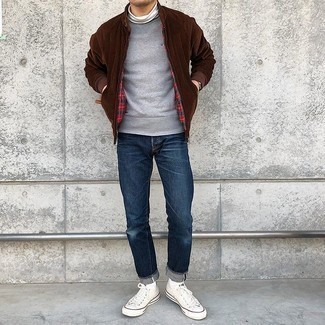 Dark Brown Bomber Jacket Outfits For Men: This laid-back combination of a dark brown bomber jacket and navy jeans is a goofproof option when you need to look casual and cool but have zero time to spare. White canvas low top sneakers are the perfect addition to your ensemble.