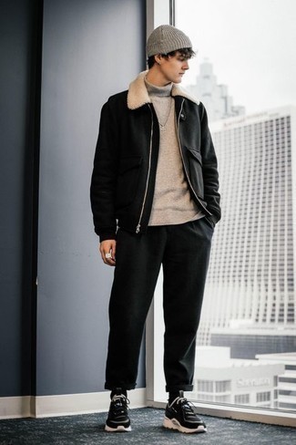Wear a black wool bomber jacket with black chinos for a laid-back and trendy outfit. Black and white athletic shoes introduce a casual aesthetic to the outfit.