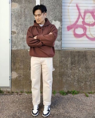 White and Black Leather Low Top Sneakers Outfits For Men: Undeniable proof that a brown hoodie and beige chinos look awesome when worn together in an off-duty outfit. Add a pair of white and black leather low top sneakers to your outfit et voila, this ensemble is complete.