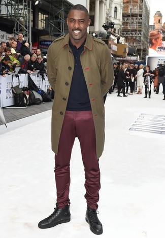Idris Elba wearing Dark Brown Leather High Top Sneakers, Burgundy Chinos, Navy Polo, Olive Trenchcoat