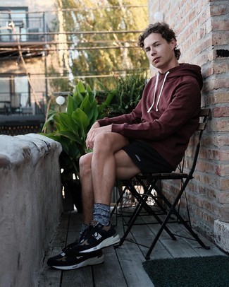 Burgundy Hoodie Outfits For Men: A burgundy hoodie and black sports shorts are a perfect pairing to be utilised on dress-down days. A pair of black athletic shoes looks perfect finishing your outfit.