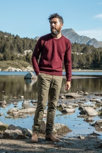 Red Sweatshirt Outfits For Men: A red sweatshirt and olive chinos are a good look to add to your day-to-day fashion mix. If in doubt about what to wear when it comes to shoes, stick to a pair of tan suede desert boots.