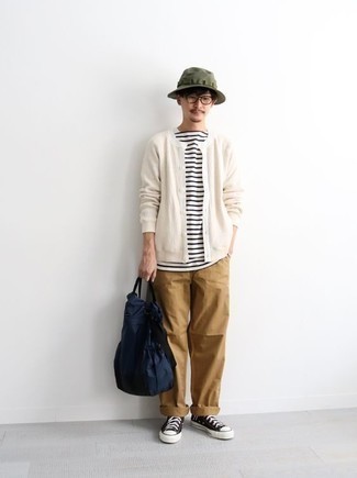 Olive Bucket Hat Outfits For Men: This combo of a white cardigan and an olive bucket hat is a safe bet for an effortlessly stylish ensemble. Introduce a pair of black and white canvas high top sneakers to this ensemble et voila, the ensemble is complete.