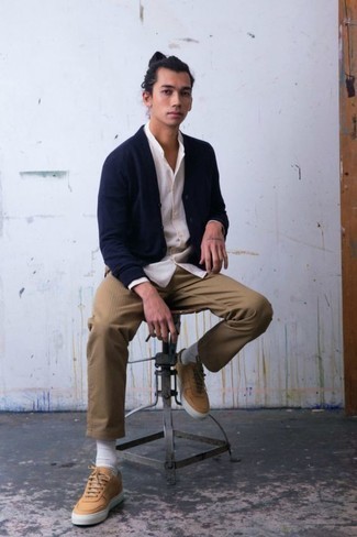 Beige Canvas Low Top Sneakers Outfits For Men: For a casual getup with a modernized spin, marry a navy cardigan with khaki chinos. If you need to easily dial down this outfit with one item, why not complement your outfit with a pair of beige canvas low top sneakers?