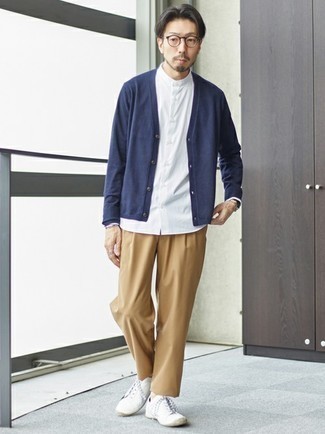 Beige Leather Watch Outfits For Men: A navy cardigan and a beige leather watch are absolute staples if you're piecing together an off-duty wardrobe that holds to the highest menswear standards. Rounding off with white canvas low top sneakers is an easy way to bring a little fanciness to this look.