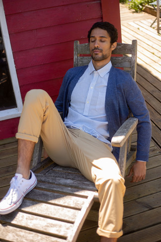 Navy Sweater Outfits For Men: This pairing of a navy sweater and khaki chinos is put together and yet it's easy enough and ready for anything. Finishing off with a pair of white canvas low top sneakers is the simplest way to add a bit of fanciness to your look.
