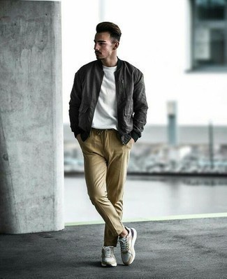 Charcoal Bomber Jacket Outfits For Men: Make a charcoal bomber jacket and khaki chinos your outfit choice for a dapper, relaxed casual look. White athletic shoes are an easy way to transform your look.