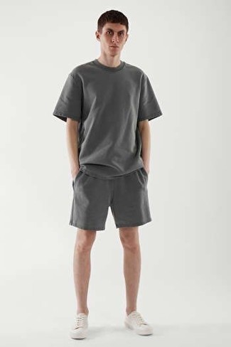 1200+ Hot Weather Outfits For Men: Try teaming a charcoal crew-neck t-shirt with charcoal sports shorts for an easy-to-create look. You can take a more refined approach with footwear and enter a pair of white canvas low top sneakers into the equation.