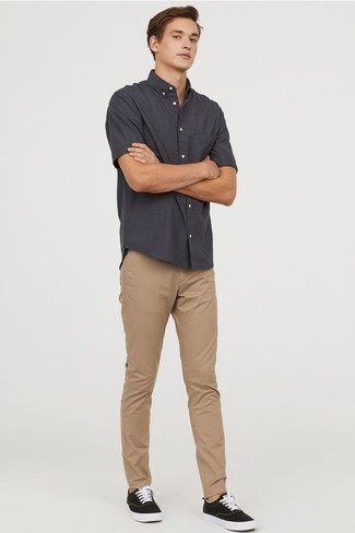 Grey Short Sleeve Shirt Outfits For Men: For a casual outfit, consider pairing a grey short sleeve shirt with khaki chinos — these pieces work perfectly together. The whole ensemble comes together when you introduce a pair of black and white canvas low top sneakers to the equation.