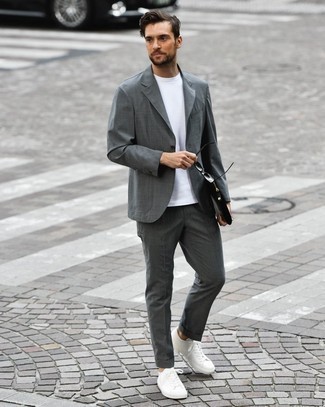 White Leather Low Top Sneakers Smart Casual Outfits For Men: Flaunt your styling game by wearing this combo of a charcoal suit and a white crew-neck t-shirt. Hesitant about how to round off? Complement your outfit with a pair of white leather low top sneakers to jazz things up.