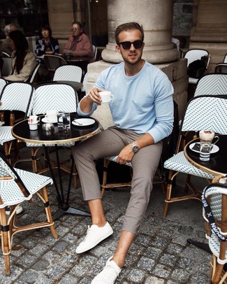 Dark Brown Check Chinos Outfits: Flaunt your skills in men's fashion by combining a light blue crew-neck sweater and dark brown check chinos for a laid-back combo. Now all you need is a nice pair of white leather low top sneakers to finish off this look.
