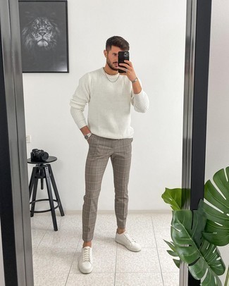 White Crew-neck Sweater Outfits For Men: Extremely dapper and functional, this off-duty pairing of a white crew-neck sweater and grey plaid chinos provides with amazing styling opportunities. A pair of white leather low top sneakers acts as the glue that ties your look together.