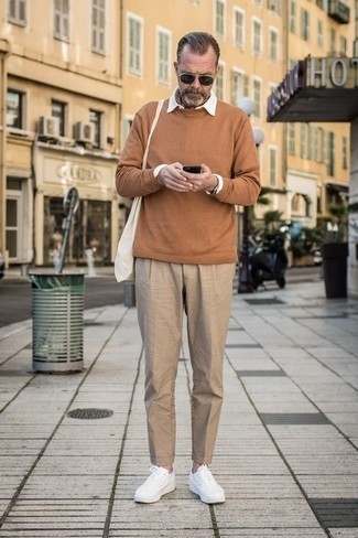 Tobacco Crew-neck Sweater Outfits For Men: A tobacco crew-neck sweater and khaki chinos teamed together are a smart match. Balance out this getup with a more relaxed kind of shoes, like this pair of white leather low top sneakers.