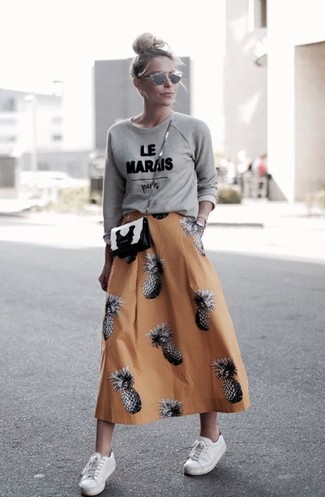Mustard Full Skirt Outfits: If the setting permits a laid-back outfit, you can go for a grey print crew-neck sweater and a mustard full skirt. White low top sneakers tie the ensemble together.
