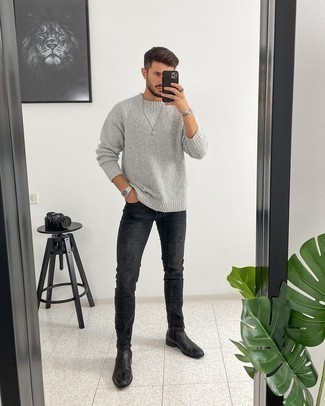Charcoal Ripped Jeans Outfits For Men: Rock a grey crew-neck sweater with charcoal ripped jeans to create a seriously dapper and city casual ensemble. If you want to instantly elevate this look with one piece, add black leather chelsea boots to the mix.