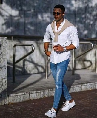 Blue Ripped Skinny Jeans Outfits For Men: Nail the effortlessly stylish look by opting for a beige crew-neck sweater and blue ripped skinny jeans. Why not complement this ensemble with a pair of white canvas low top sneakers for an added touch of style?