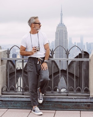 1200+ Hot Weather Outfits For Men: Rock a white crew-neck t-shirt with charcoal cargo pants to get a street style and absolutely dapper look. A pair of blue print canvas low top sneakers will be the ideal complement to your ensemble.