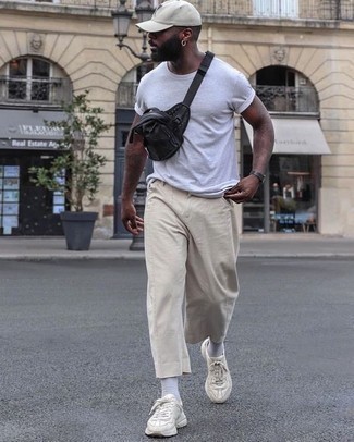 Black Canvas Fanny Pack Outfits For Men: Consider wearing a white crew-neck t-shirt and a black canvas fanny pack for a relaxed twist on day-to-day menswear. Want to break out of the mold? Then why not add a pair of beige athletic shoes to the mix?