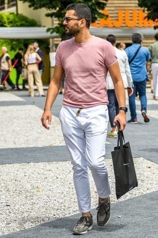 Black Canvas Tote Bag Outfits For Men: We're all seeking practicality when it comes to styling, and this contemporary combination of a pink crew-neck t-shirt and a black canvas tote bag is a vivid example of that. Introduce grey athletic shoes to your outfit for an extra touch of style.