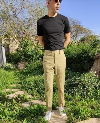 1200+ Casual Hot Weather Outfits For Men: This pairing of a black crew-neck t-shirt and khaki chinos is extremely easy to do and so comfortable to work over the course of the day as well! The whole look comes together quite nicely when you introduce a pair of white canvas low top sneakers to this outfit.