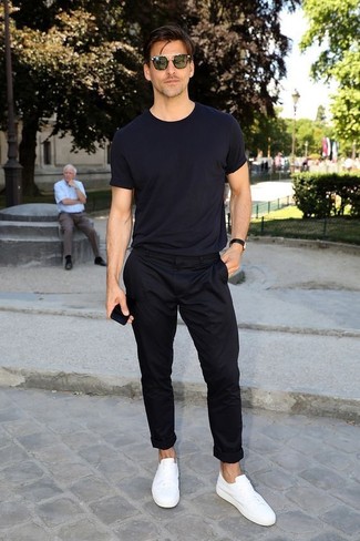 Black Chinos Hot Weather Outfits: Sharp yet comfortable, this getup is assembled from a black crew-neck t-shirt and black chinos. White leather low top sneakers are the perfect complement for this ensemble.