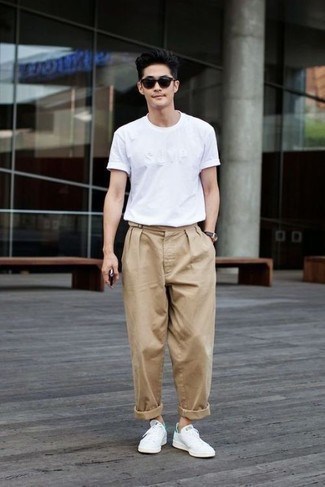Beige Chinos Hot Weather Outfits: Pair a white crew-neck t-shirt with beige chinos for a simple outfit that's also put together nicely. A pair of white leather low top sneakers is a savvy option to finish your ensemble.