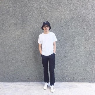 Navy Bucket Hat Outfits For Men: You'll be amazed at how easy it is for any man to throw together a casual street style ensemble like this. Just a white crew-neck t-shirt and a navy bucket hat. For a smarter feel, why not complement this outfit with a pair of white and black canvas low top sneakers?