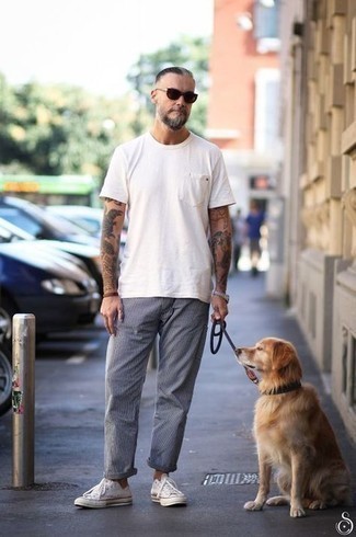 Grey Vertical Striped Chinos Outfits: For effortless style without the need to sacrifice on functionality, we turn to this combination of a white crew-neck t-shirt and grey vertical striped chinos. This look is completed wonderfully with a pair of white canvas low top sneakers.
