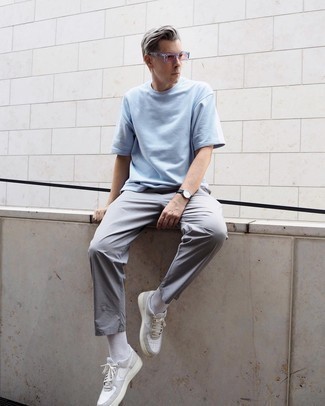 White Leather Low Top Sneakers Outfits For Men: Opt for a light blue crew-neck t-shirt and grey chinos to create a day-to-day getup that's full of charisma and personality. Complement this look with white leather low top sneakers and the whole ensemble will come together perfectly.