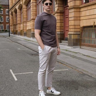 Dark Brown Crew-neck T-shirt Outfits For Men: Pair a dark brown crew-neck t-shirt with grey chinos to create an interesting and modern-looking casual ensemble. Complement your outfit with a pair of white and black leather low top sneakers and ta-da: your look is complete.