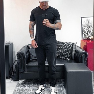 White and Red Leather Low Top Sneakers Outfits For Men: A black crew-neck t-shirt and black chinos combined together are the ideal outfit for those dressers who appreciate casually dapper outfits. All you need is a cool pair of white and red leather low top sneakers to complete this ensemble.