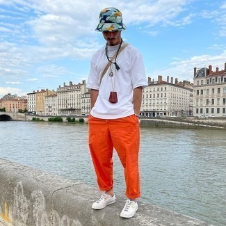 Orange Chinos Outfits: You're looking at the indisputable proof that a white crew-neck t-shirt and orange chinos are awesome when matched together in a casual getup. Let your sartorial chops truly shine by finishing your getup with white canvas low top sneakers.