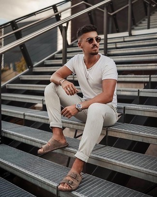 Tan Suede Sandals Outfits For Men: A white crew-neck t-shirt and grey vertical striped chinos are the kind of a winning casual ensemble that you need when you have zero time. Introduce tan suede sandals to this ensemble to add a sense of stylish casualness to this getup.