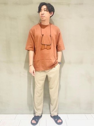 500+ Relaxed Hot Weather Outfits For Men: This combination of an orange crew-neck t-shirt and beige chinos is an interesting balance between off-duty and stylish. Black canvas sandals are an effortless way to power up this outfit.