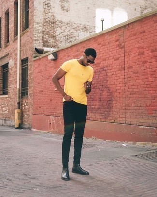 Mustard Crew-neck T-shirt Outfits For Men: This combination of a mustard crew-neck t-shirt and black jeans is extremely easy to imitate and so comfortable to rock over the course of the day as well! Black leather chelsea boots will instantly elevate even the most casual of getups.