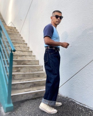 500+ Hot Weather Outfits For Men: A light blue print crew-neck t-shirt and navy jeans paired together are a sartorial dream for those dressers who love casually stylish styles. Look at how nice this getup goes with a pair of beige canvas high top sneakers.