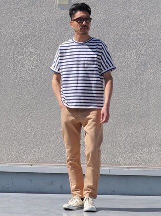 Beige Low Top Sneakers Outfits For Men: This laid-back combo of a white and navy horizontal striped crew-neck t-shirt and khaki jeans is a tested option when you need to look stylish but have no time. Let your styling prowess truly shine by finishing off your outfit with a pair of beige low top sneakers.