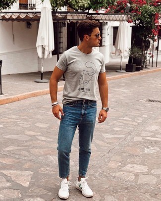 White and Green Leather Low Top Sneakers Outfits For Men: Wear a grey print crew-neck t-shirt with blue jeans for both dapper and easy-to-achieve getup. This ensemble is rounded off really well with white and green leather low top sneakers.