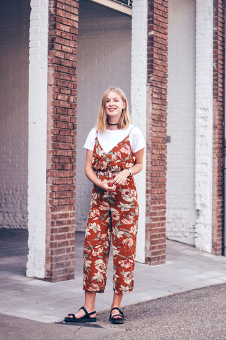 44 Outfits For Women In Their Teens: If you love relaxed dressing, why not take this combo of a white crew-neck t-shirt and a red floral jumpsuit for a walk? Want to tone it down with footwear? Complete your outfit with a pair of black leather flat sandals for the day.