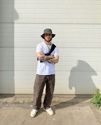 Dark Green Bucket Hat Outfits For Men: For an outfit that delivers comfort and fashion, consider wearing a white crew-neck t-shirt and a dark green bucket hat. White canvas low top sneakers will bring a hint of elegance to an otherwise everyday look.